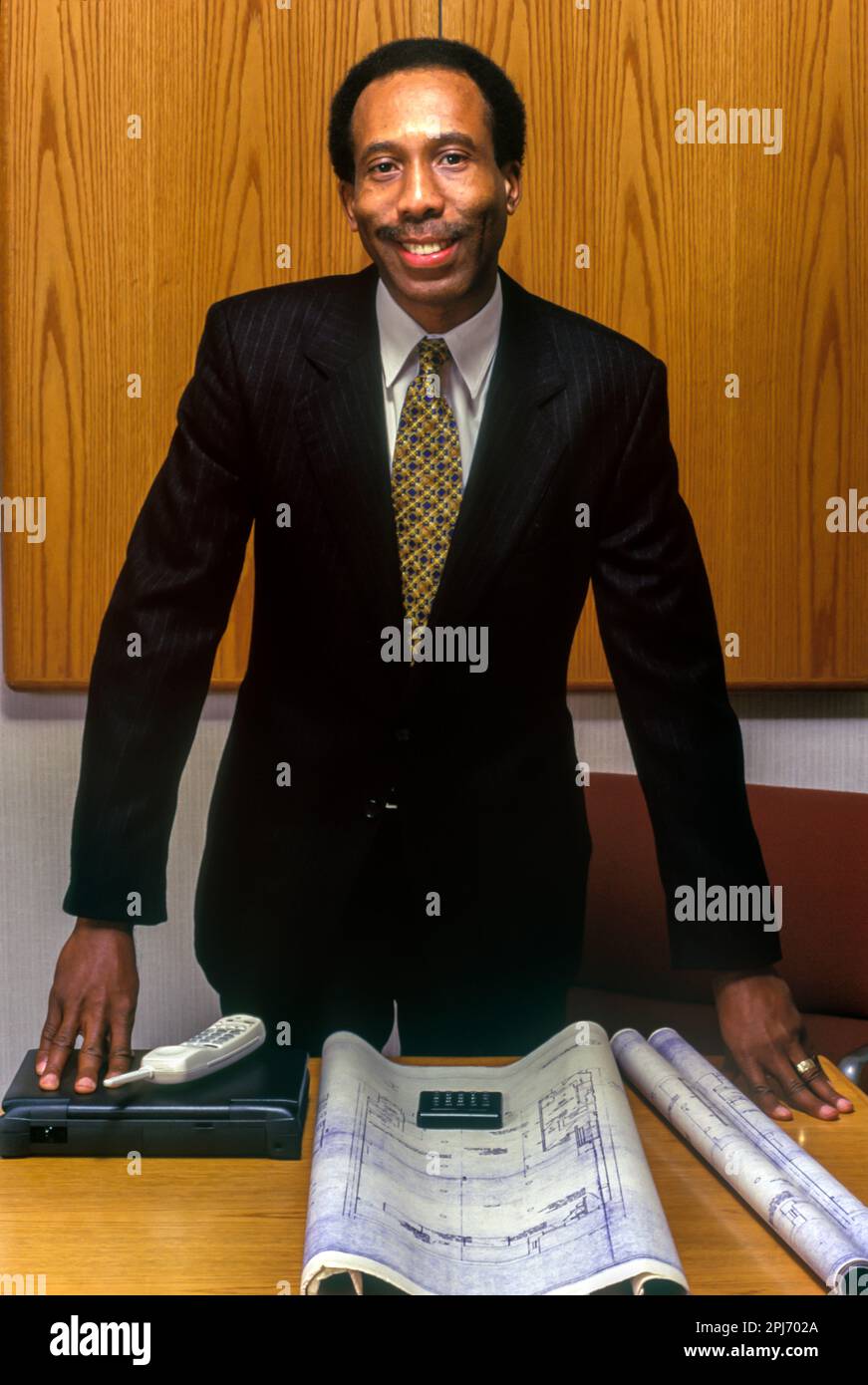 1996 STORICO UOMO NERO UFFICIO LAVORATORE CON PIANI DI COSTRUZIONE Foto Stock