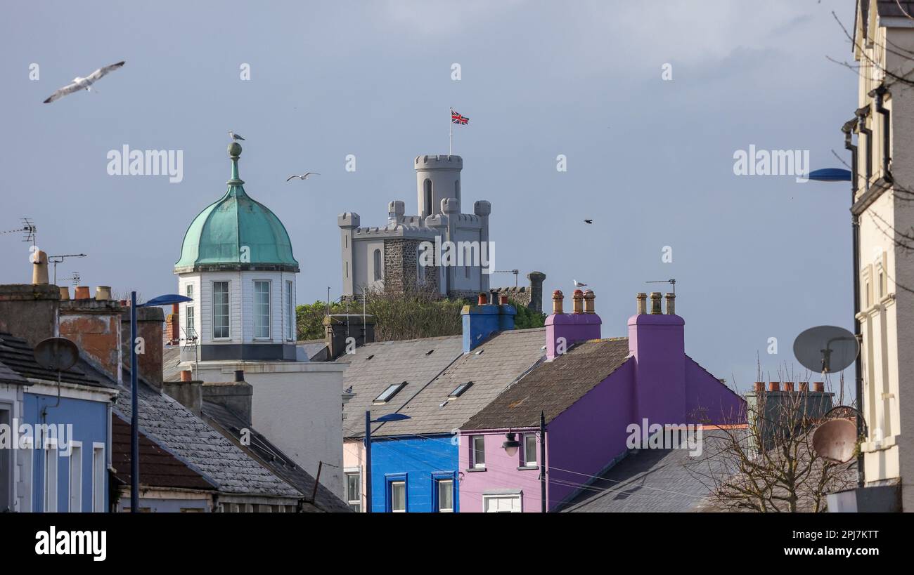 Vista degli edifici nel centro di Donaghadee nelle giornate primaverili soleggiate con il Castello di Donaghadee motte sullo sfondo. Foto Stock