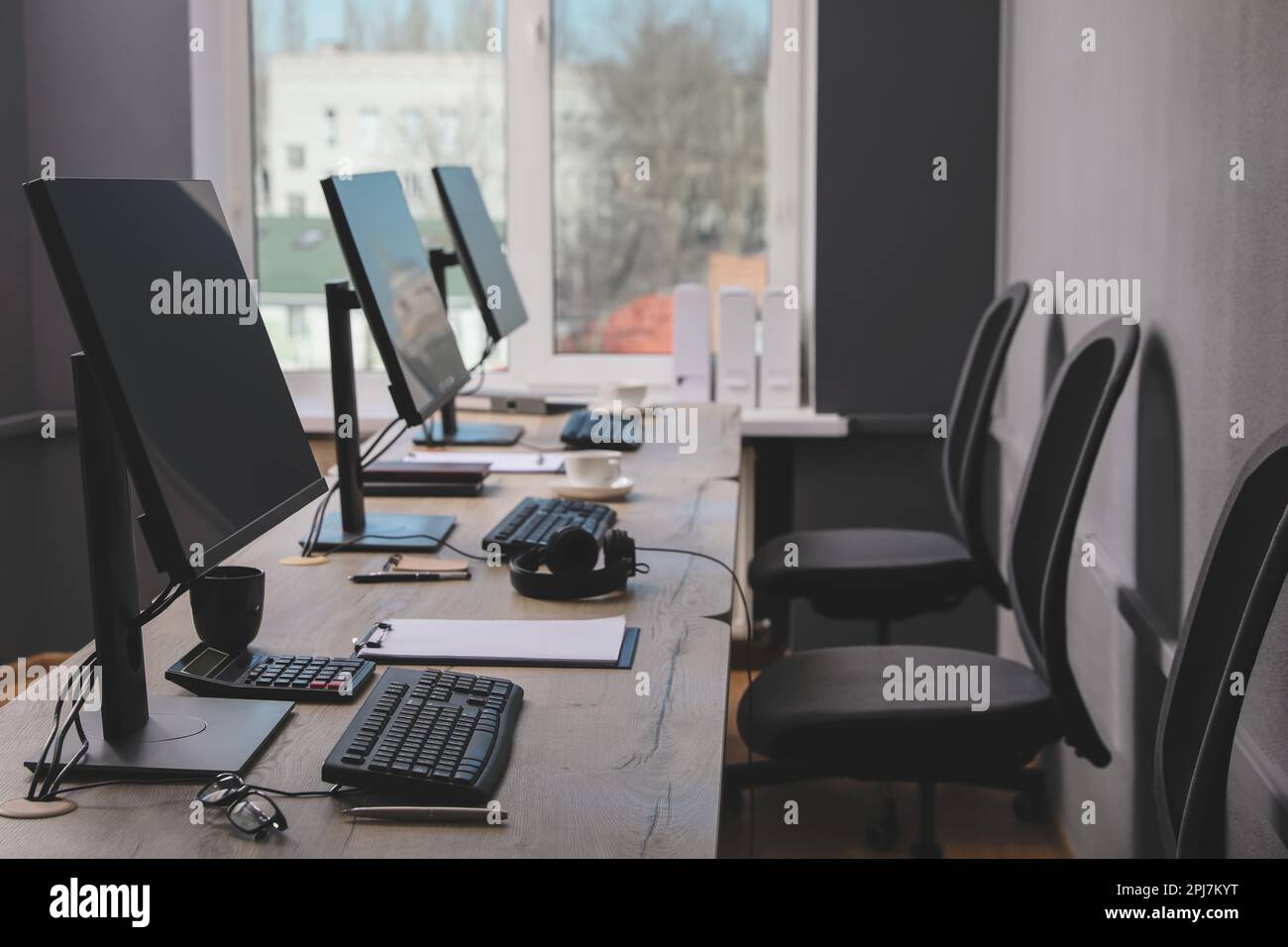 Interno ufficio aperto. Posti di lavoro moderni con computer vicino alla finestra Foto Stock