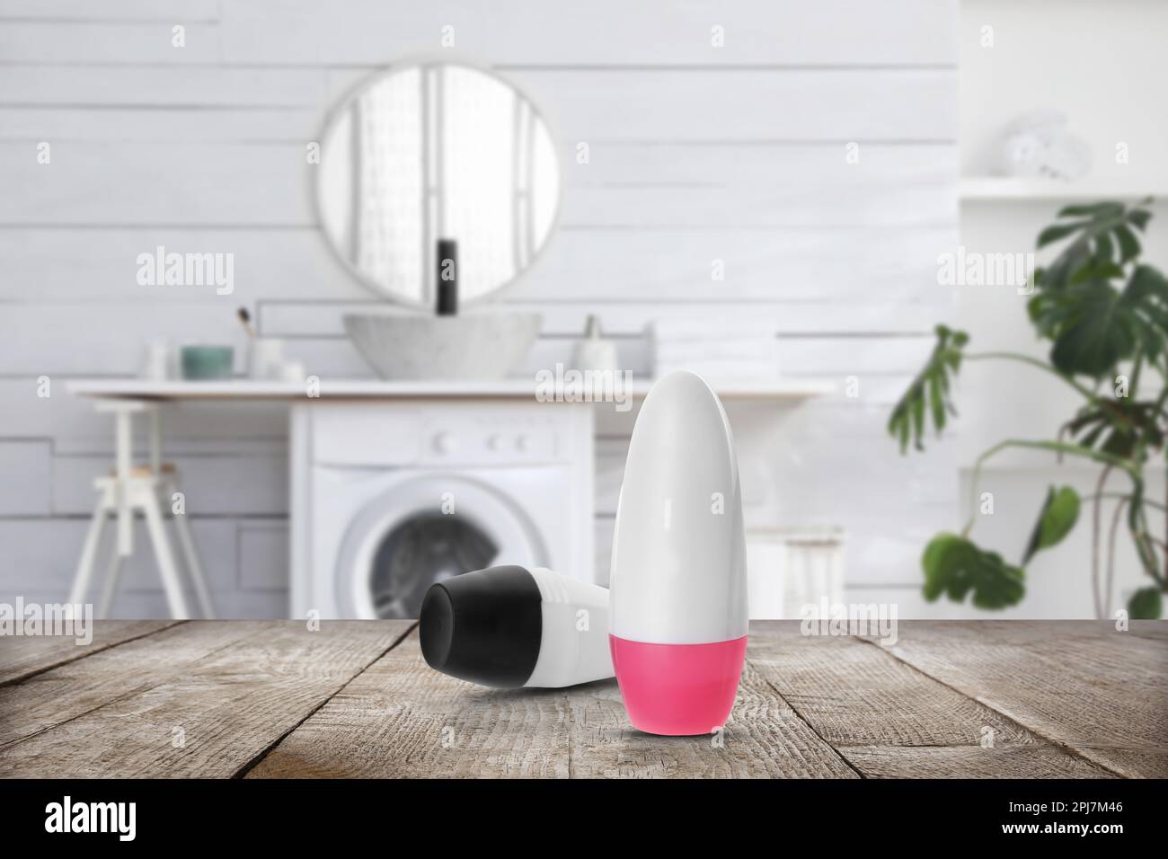 Diversi deodoranti avvolgibili su tavolo in legno in bagno. Modello per il design Foto Stock
