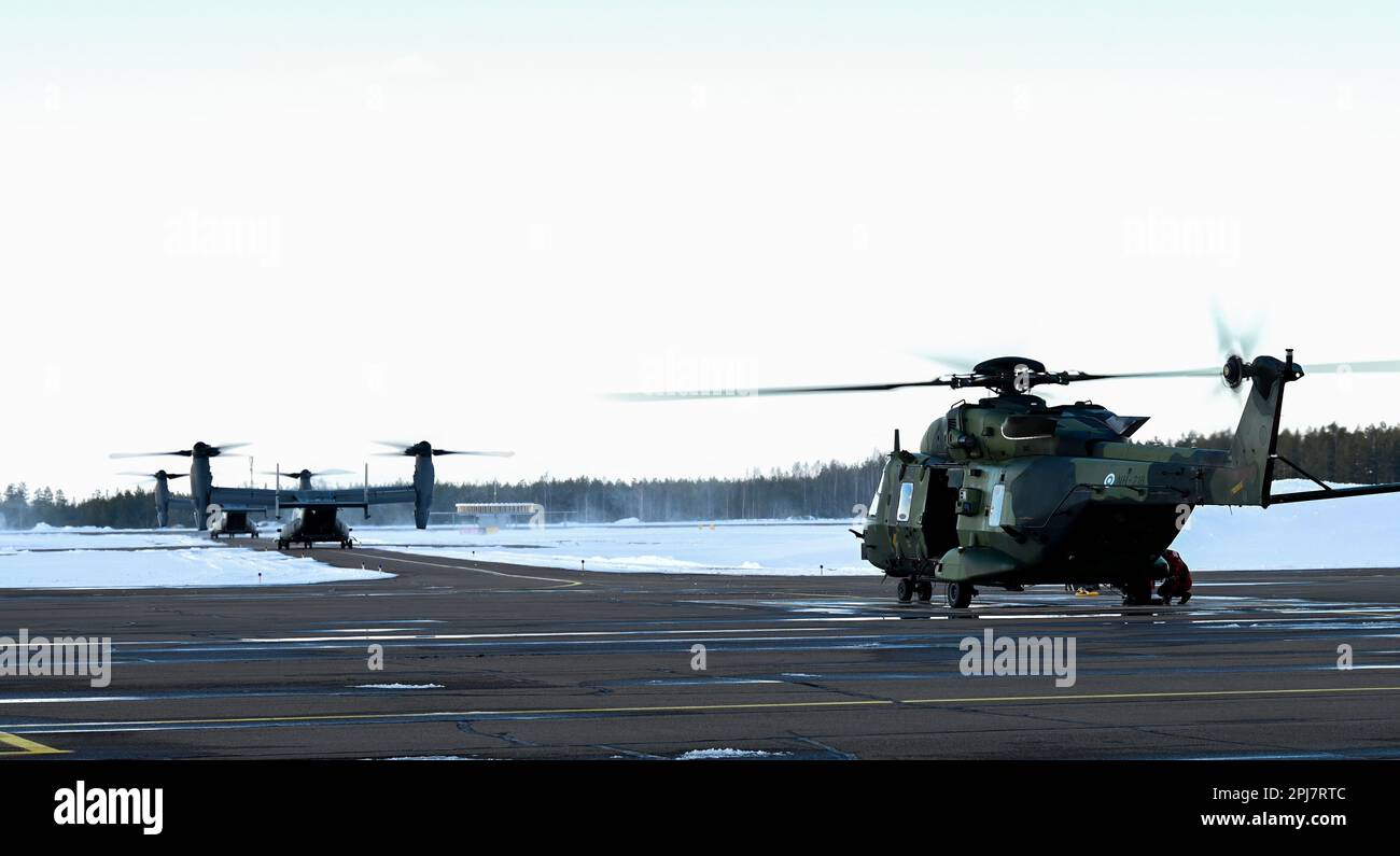 Due Stati Uniti Air Force CV-22B Ospreys con la 352d Special Operations Wing e un elicottero finlandese NH90 con l'Utti Jaeger Regiment Helicopter Battalion si preparano a decollare durante un esercizio bilaterale presso la Utti Air base, Finlandia, 30 marzo 2023. Insieme, le forze statunitensi e i nostri partner e nazioni alleate affinano le competenze, ottimizzano l'interoperabilità, coltivano relazioni chiave e si acclimatano alle sfide intrinseche poste dalle condizioni climatiche estreme dell'Artico allenandosi nell'Alto Nord. (STATI UNITI Foto Air Force di Tech. Izabella Workman) Foto Stock