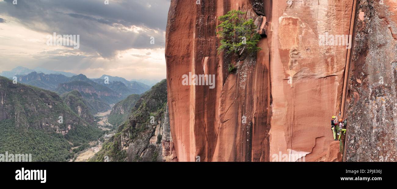 Donna e uomo che si arrampicano su montagne remote in Cina Foto Stock