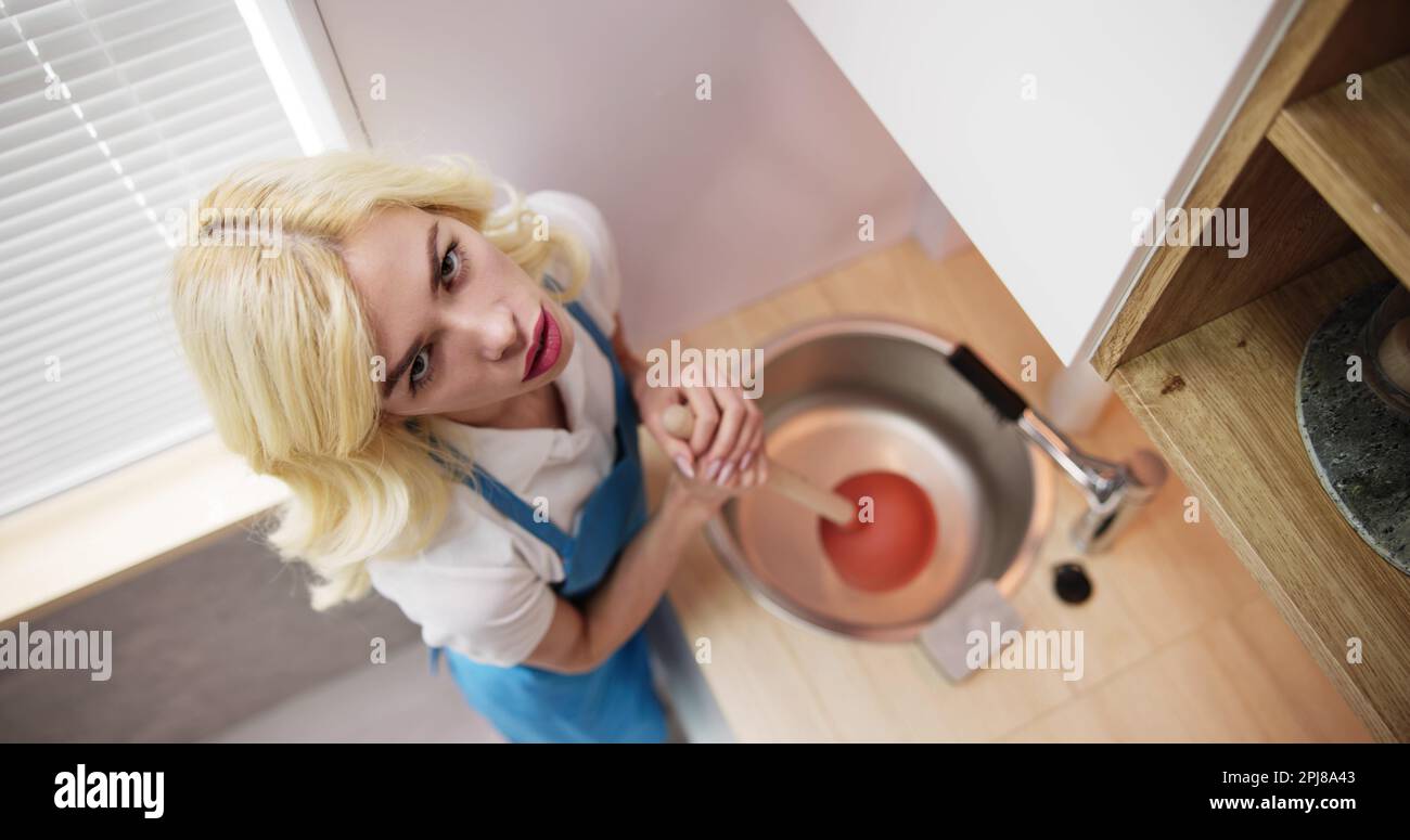 Pulizia del lavandino bloccato e scarico in cucina con il pistone Foto Stock