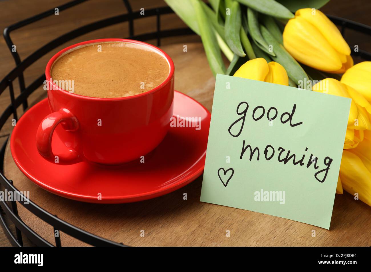 Bellissimi tulipani gialli, tazza di caffè aromatico e buona nota mattutina su vassoio di legno Foto Stock