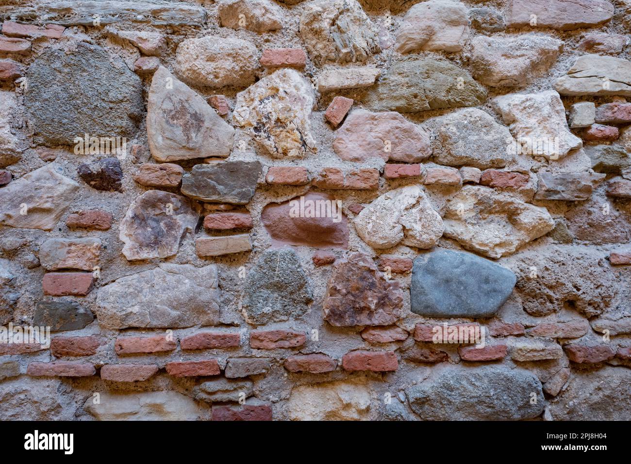 Muro di pietra e mattoni di un antico edificio. Adatto come sfondo e sfondo. Foto Stock