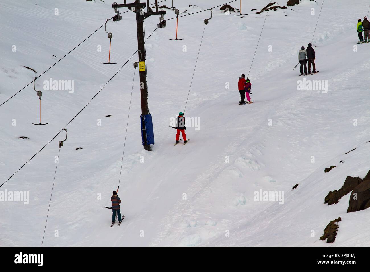 Traino da sci in funzione con diversi sciatori in salita sul monte Ruapehu in nuova Zelanda Foto Stock