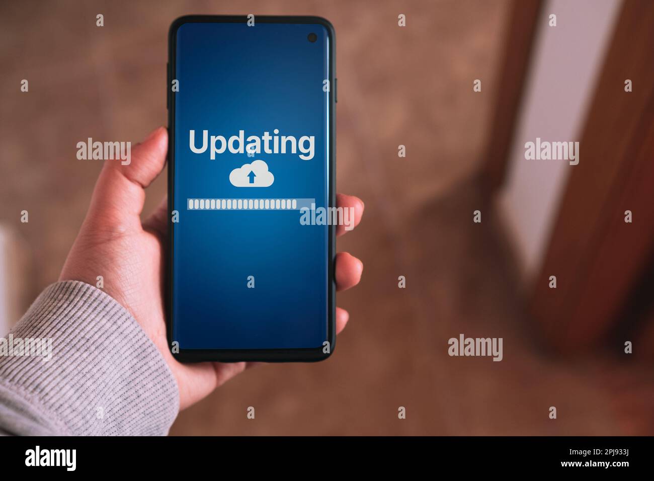 Donna che aggiorna il software sullo smartphone. Ingegnere di sistema e programmazione. Sviluppatore di applicazioni software. Foto Stock