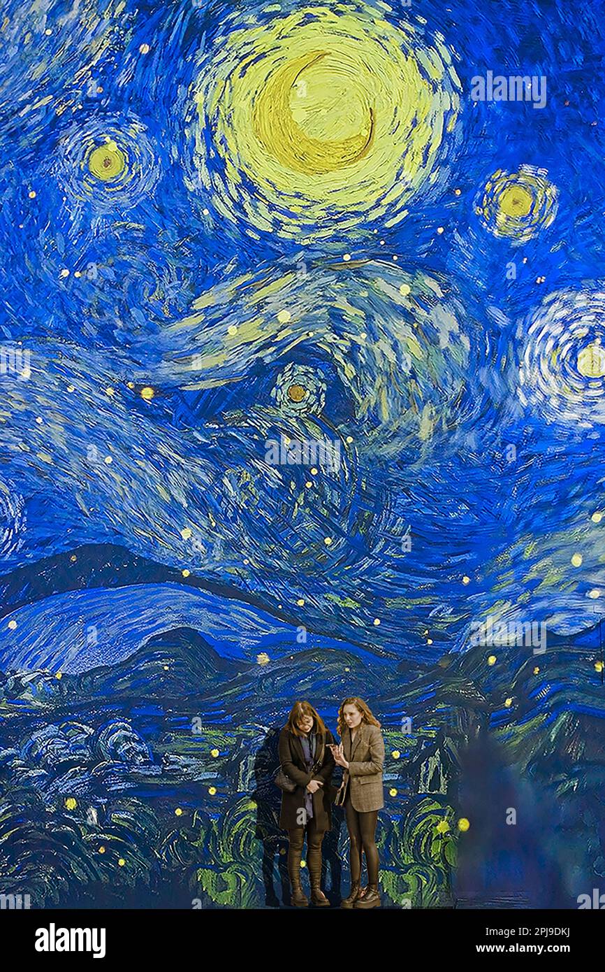 8 marzo 2023 Van Gogh Immersion Exhibition Spitalfields London UK sala di immersione due femmine davanti a una grande immagine grafica animata dietro di loro Foto Stock