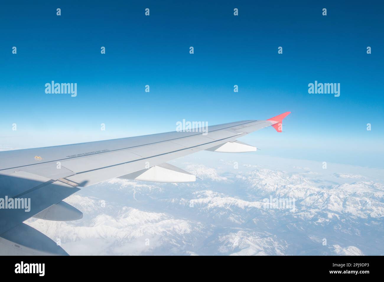 Ala di un velivolo a basso costo ad alta quota con vista del cielo blu e delle nuvole. Foto Stock