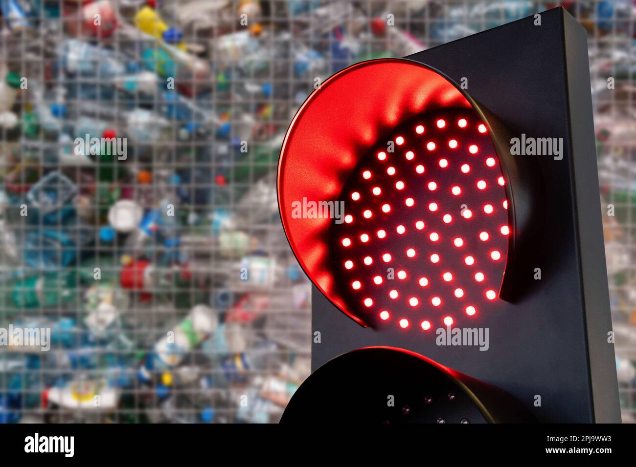 Semaforo rosso su uno sfondo di rifiuti di plastica. Foto di alta qualità Foto Stock