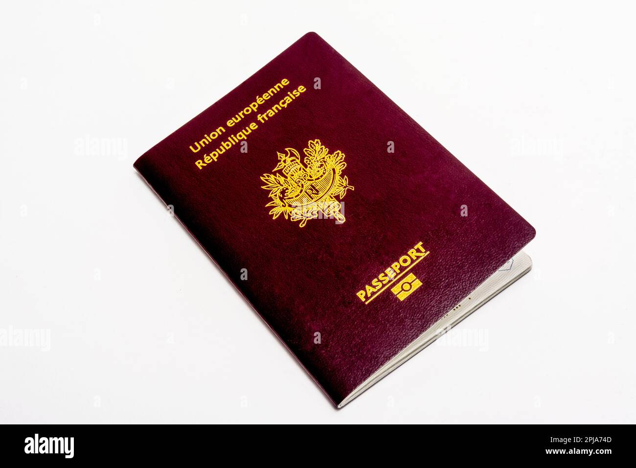 Passaporto francese appoggiato su una superficie bianca, che ne mette in risalto il design e i dettagli della copertina Foto Stock