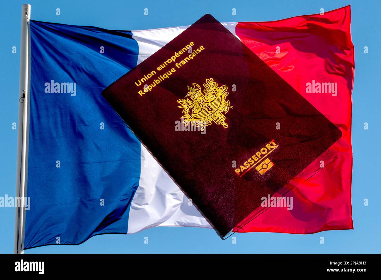 Un passaporto francese si trova sullo sfondo dei colori blu, bianco e rosso della bandiera francese. Foto Stock