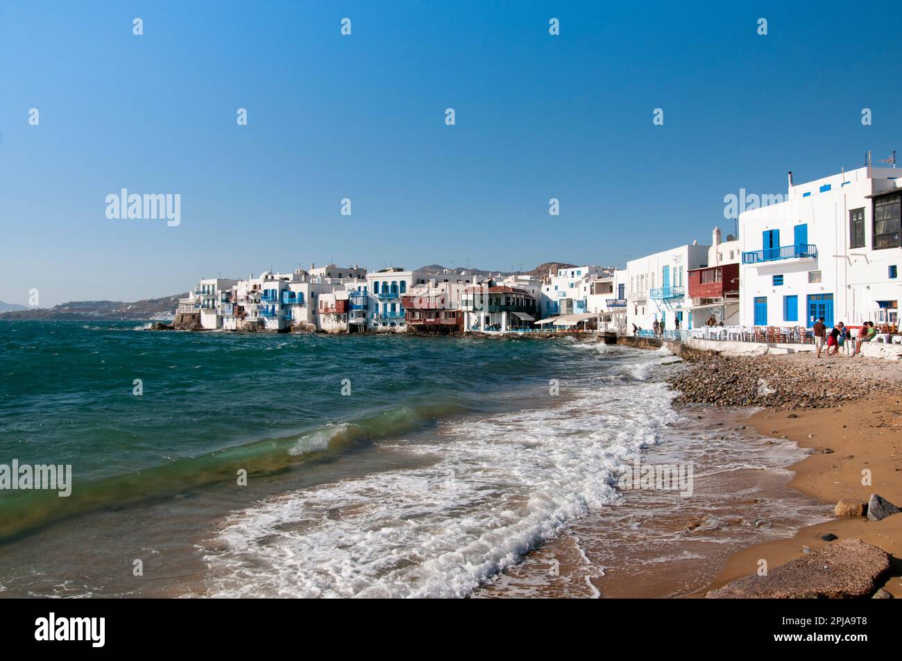 Vista dalla spiaggia le case bianche sul mare del villaggio di Chora sull'isola di Mykonos in Grecia. Sullo sfondo il cielo blu durante l'estate Foto Stock