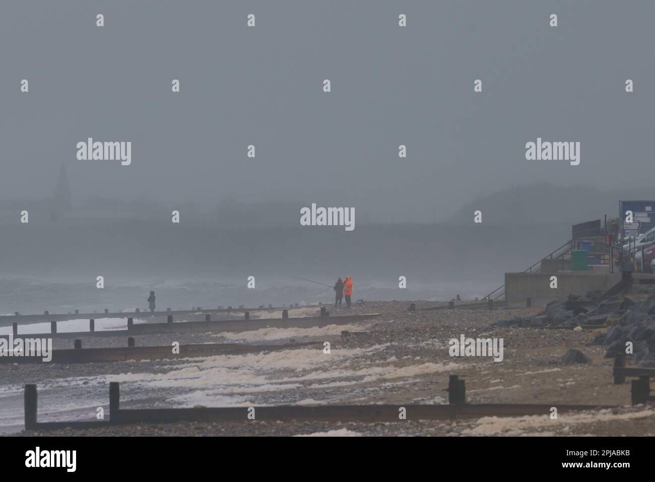 Aprile 1st 2023. Hornsea, E.Yorkshire. Un pomeriggio arrugginito e misteriosa, con la pioggia visibile sul Mare del Nord. NELLA FOTO: I pescatori gettano una linea nelle onde. Bridget Catterall/AlamyLiveNews Foto Stock