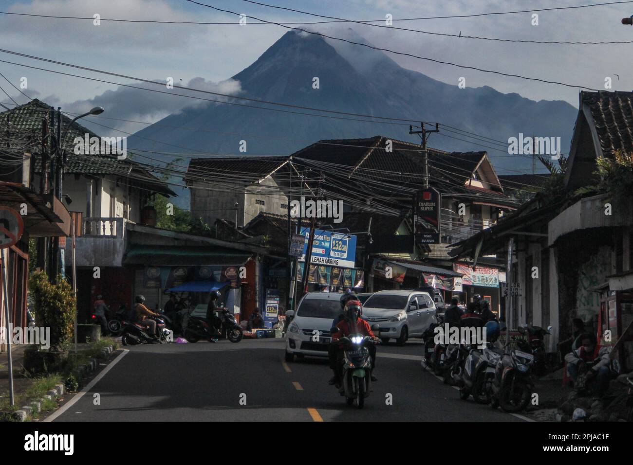 Sleman, Yogyakarta, Indonesia. 1st Apr, 2023. I motociclisti passano sullo sfondo del Monte Merapi a Sleman, Yogyakarta, Indonesia, sabato 1 aprile, 2023. Il monte Merapi è a un livello allerta e spesso emette nuvole calde e lava incandescente verso i fiumi Bebeng, Krasak e Boyong per un livello pericoloso a una distanza da 5 a 7 chilometri dalla cima del monte Merapi. (Credit Image: © Slamet Riyadi/ZUMA Press Wire) SOLO PER USO EDITORIALE! Non per USO commerciale! Foto Stock