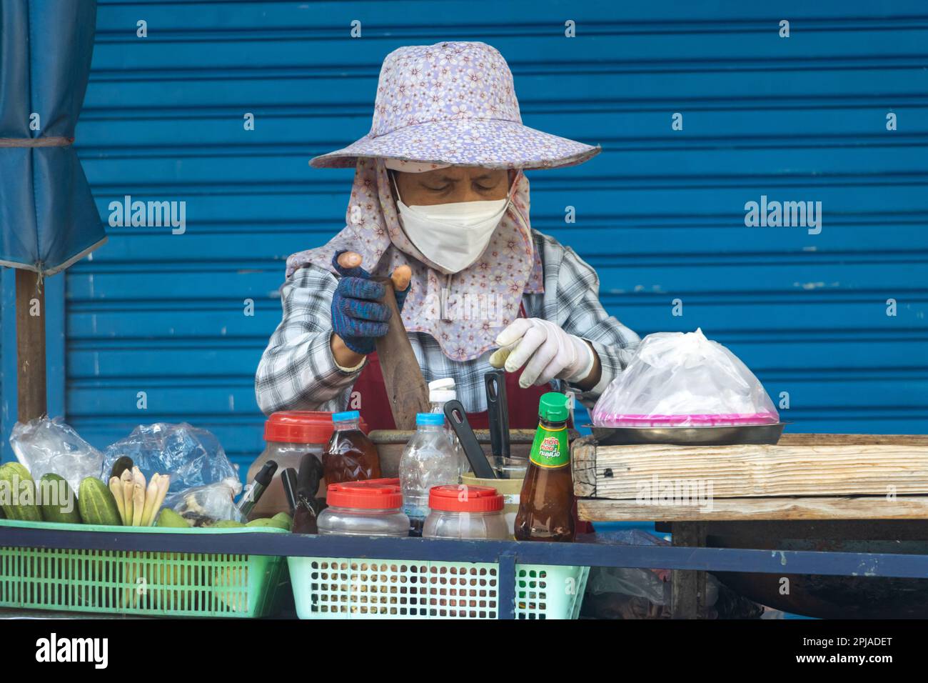 SAMUT PRAKAN, THAILANDIA, 21 2023 GENNAIO, Un venditore di strada prepara insalata di papaya per i clienti Foto Stock