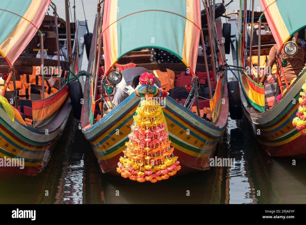 Tradizionali barche in legno decorate con fiori al naso sono ormeggiate al molo, Bangkok, Thailandia Foto Stock