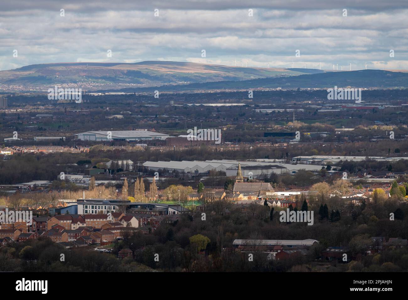 Vista sulla parte orientale di Manchester, Inghilterra, fino alle colline e alle brughiere, con fattorie eoliche a nord della città. Foto Stock