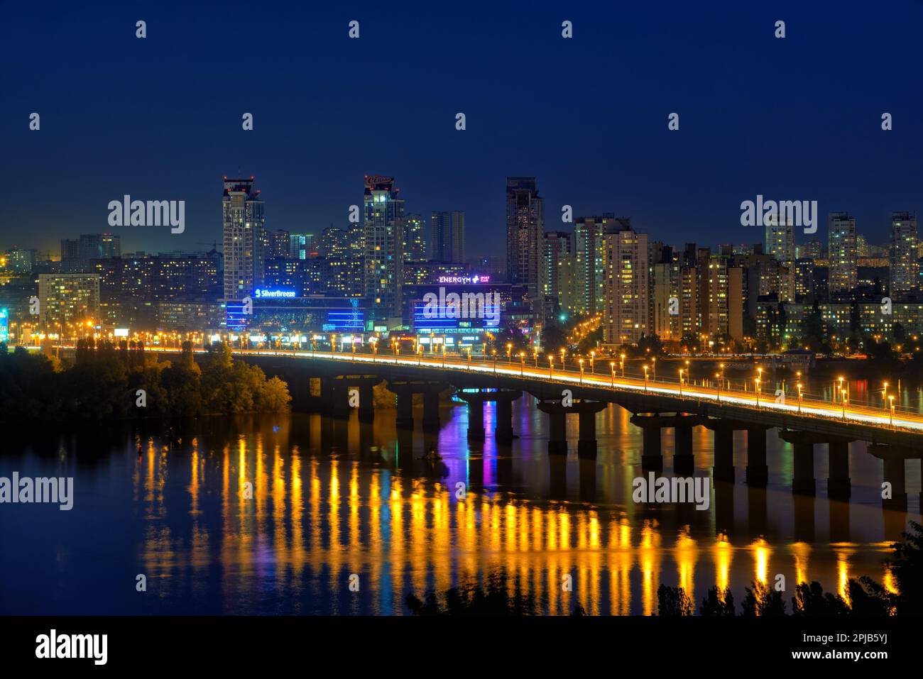 Kiev, Ucraina - 21 maggio 2015: Pittoresco paesaggio urbano notturno del fiume Dnieper e del Ponte di Paton sullo sfondo di alti edifici nel Foto Stock