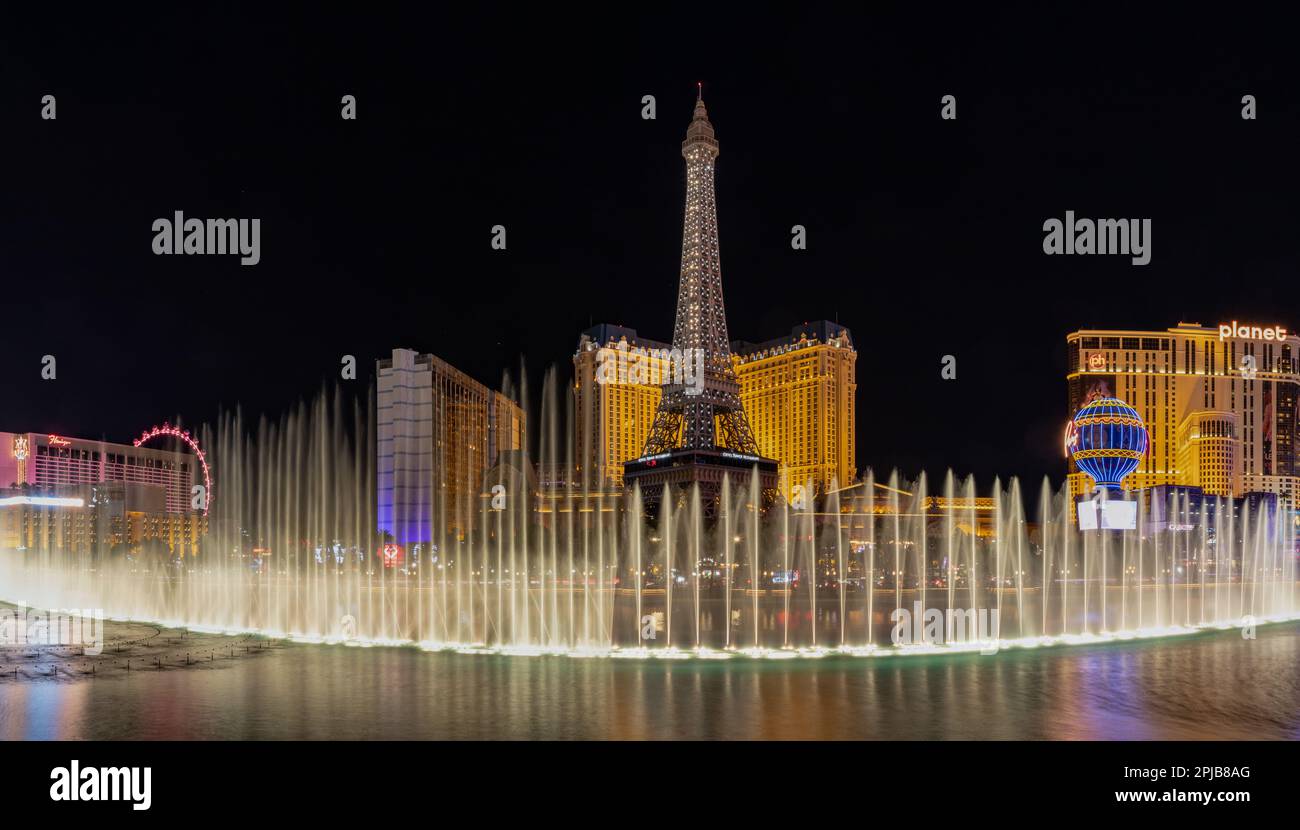 Una foto dello spettacolo d'acqua della Fontana di Bellagio di notte, con la Torre Eiffel di Parigi Las Vegas dietro di essa. Foto Stock