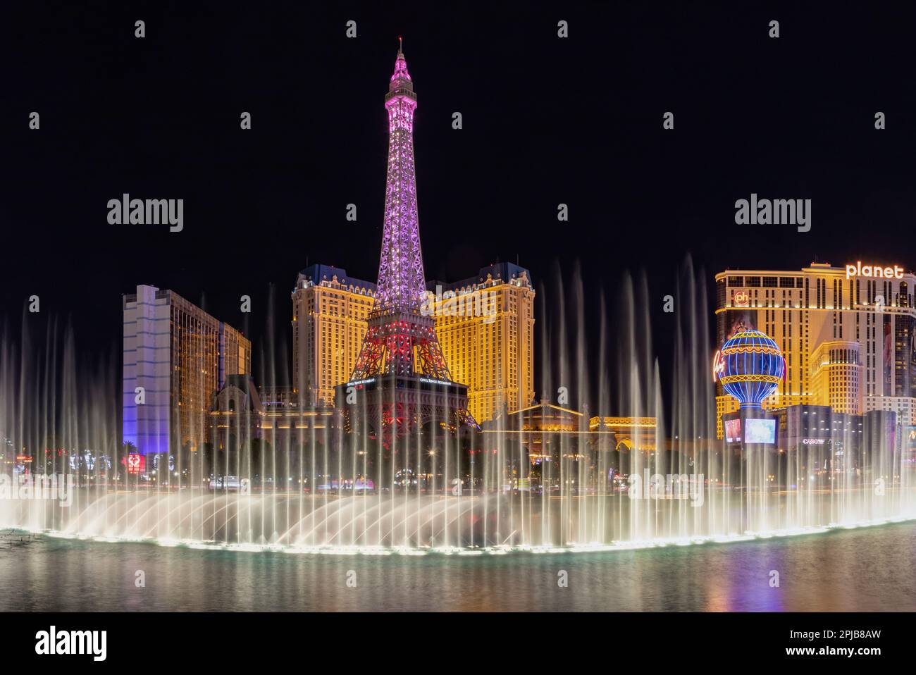 Una foto dello spettacolo d'acqua della Fontana di Bellagio di notte, con la Torre Eiffel di Parigi Las Vegas dietro di essa. Foto Stock