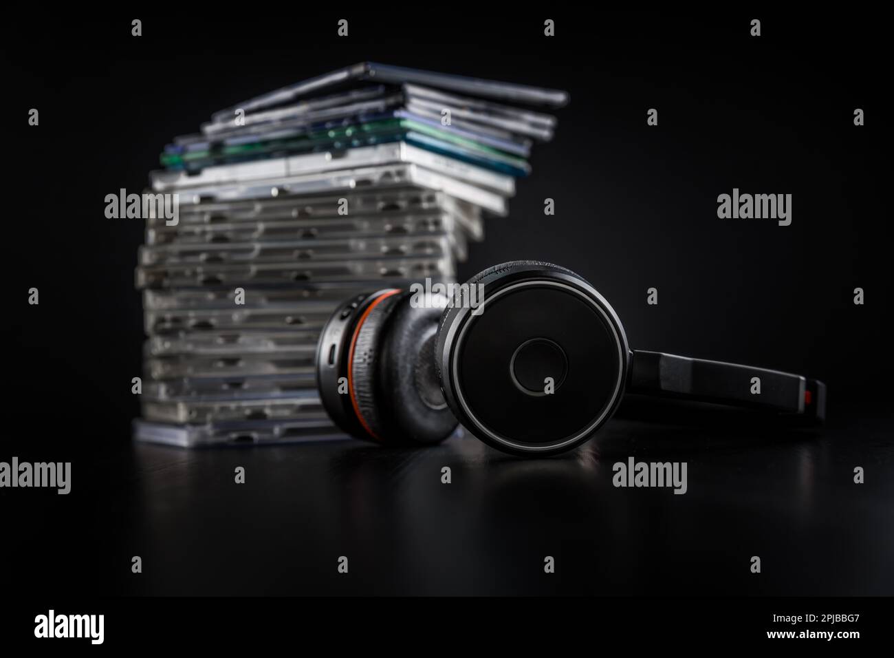 Cuffie Hi-Fi su una pila di CD su sfondo nero con spazio per le copie Foto Stock