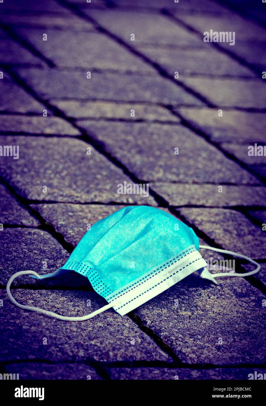 La maschera usata si trova sul marciapiede, in formato verticale Foto Stock
