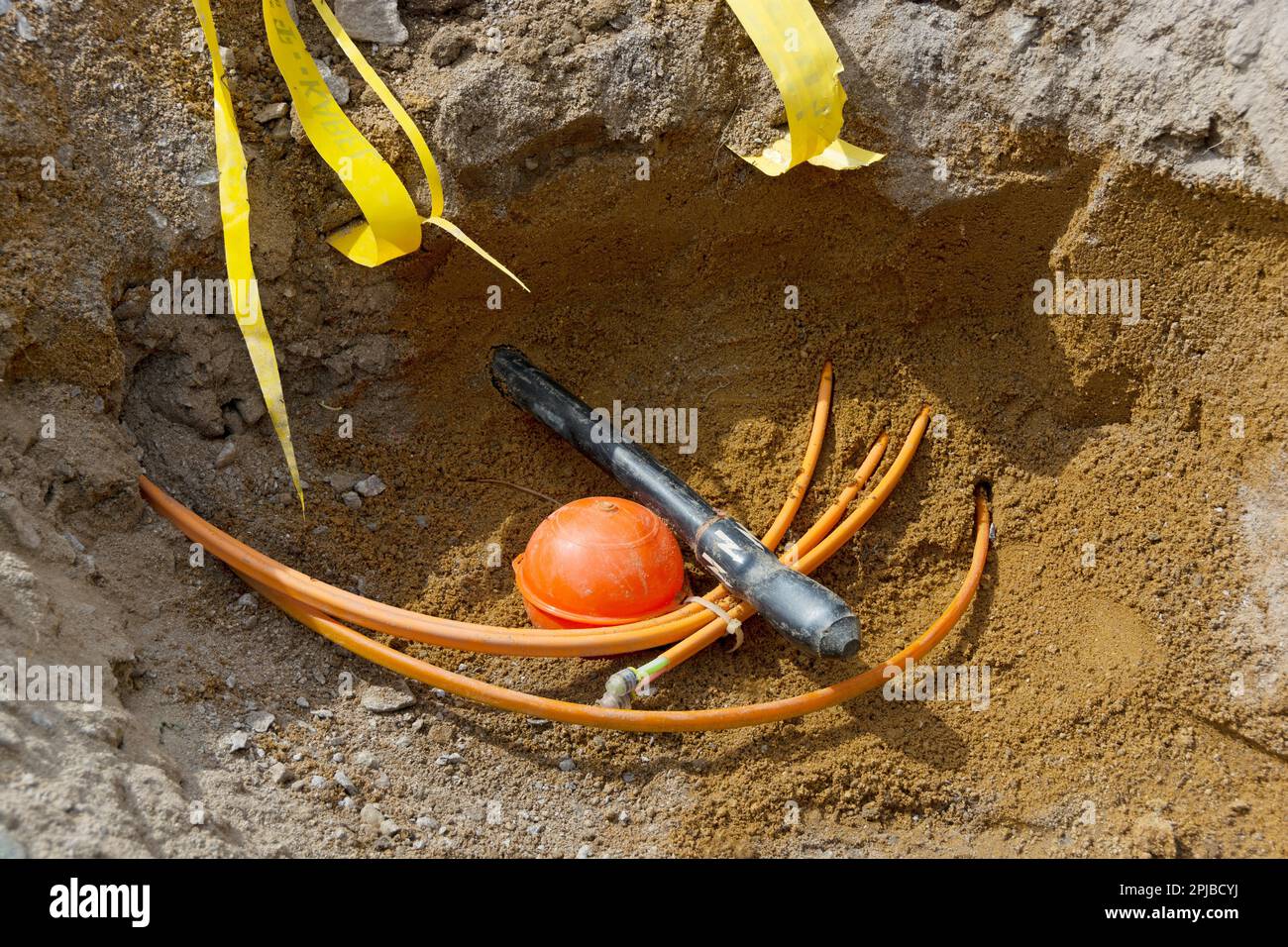 Trench con cavo in fibra ottica e cavo di alimentazione Foto Stock