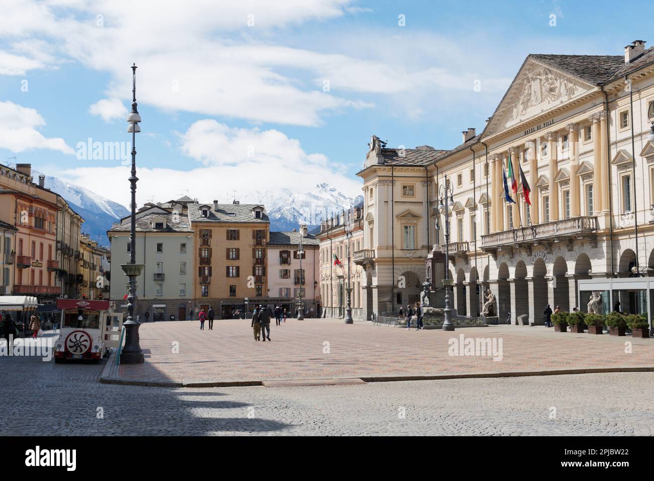 La piazza principale di Aosta, Piazza Emile Chanoux con il municipio a destra e le montagne innevate dietro. Valle d'Aosta Italia Foto Stock