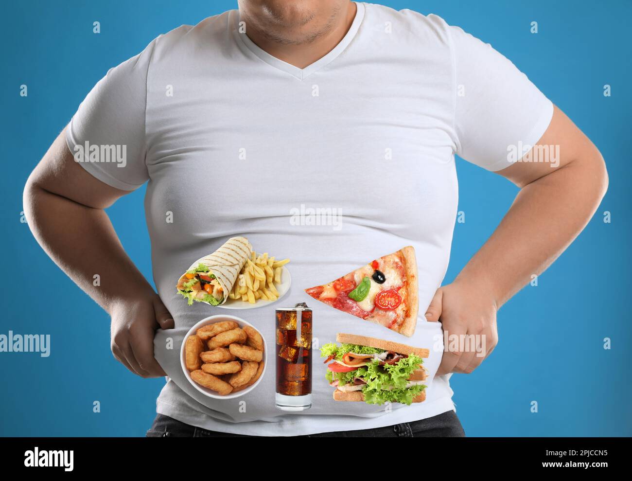Uomo sovrappeso in maglietta stretta con immagini di diversi cibi malsani sul suo ventre contro sfondo azzurro Foto Stock