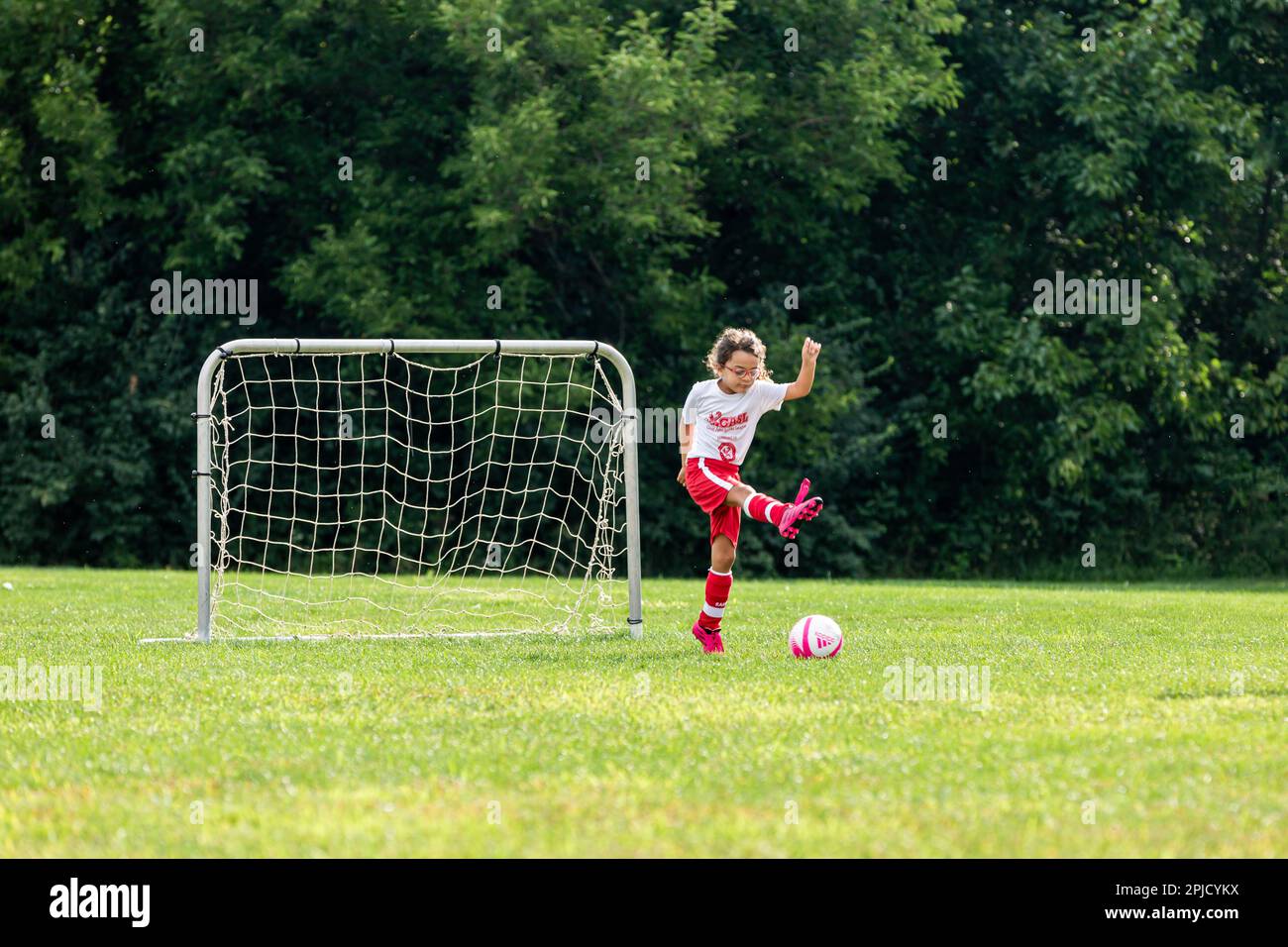 Una ragazza calcia una palla di calcio durante una partita della Geist Area Soccer League a McCordsville, Indiana, USA. Foto Stock
