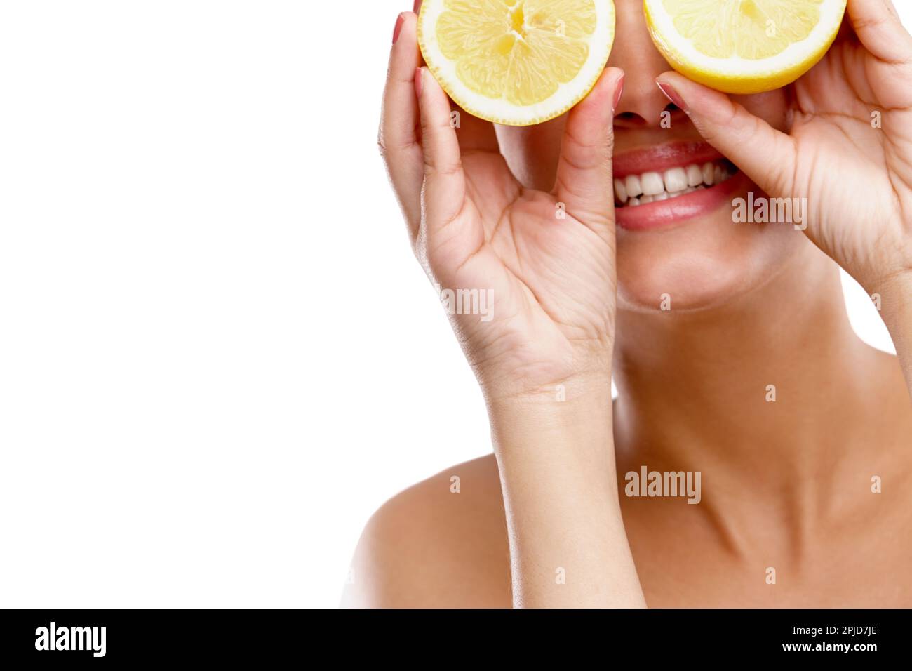 Quando la vita vi dà limoni... Studio colpo di una giovane donna che tiene due metà di un limone davanti ai suoi occhi. Foto Stock