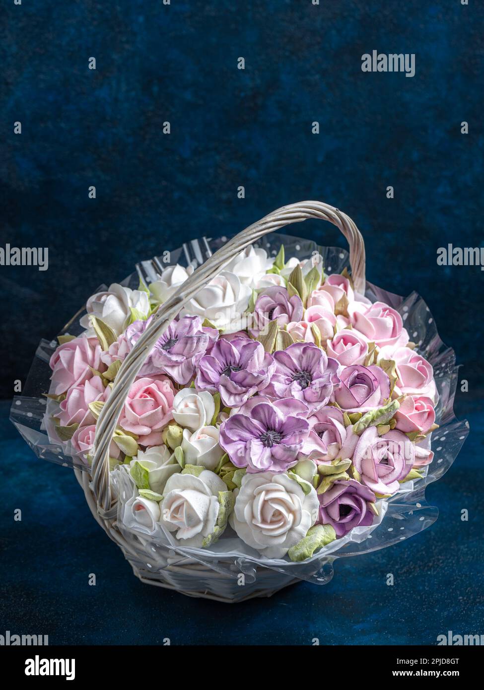 bouquet di fiori marshmallow in un cesto su sfondo blu, dolci per buongustai Foto Stock