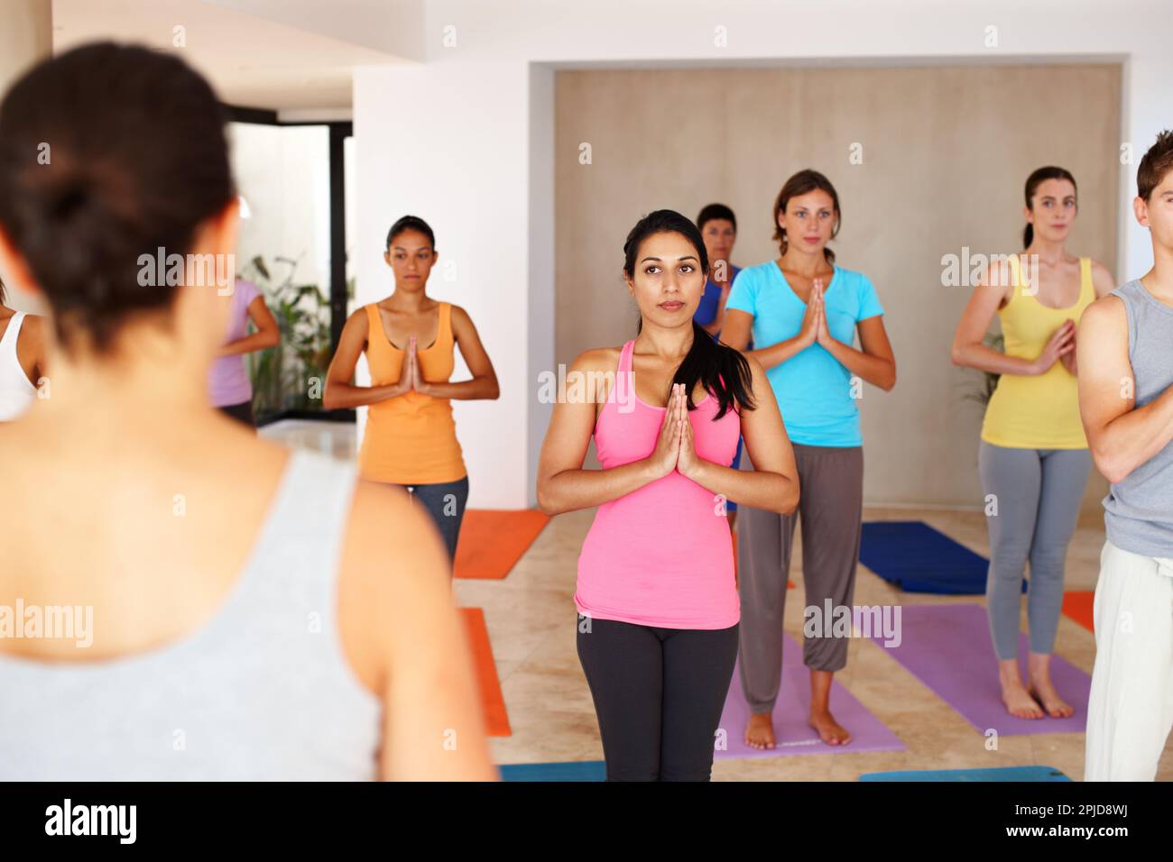 Insegnare loro lo stile di vita di zen. Un istruttore che si trova di fronte alla sua lezione di yoga. Foto Stock