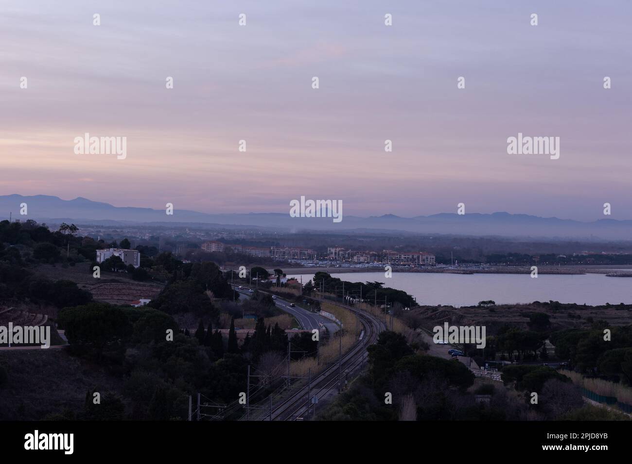 Immagine aerea di Collioure dopo il tramonto in toni di rosa e blu. Vista della città con skyline e mare Mediterraneo. Foto Stock