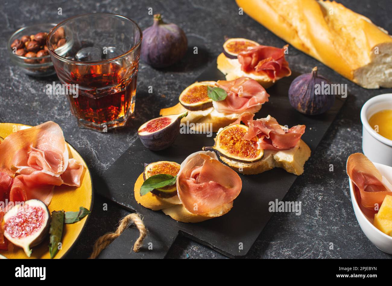 Antipasti con tradizionale set di tapas spagnole. Bruschetta all'italiana con prosciutto, formaggio spalmabile e fico. Foto Stock