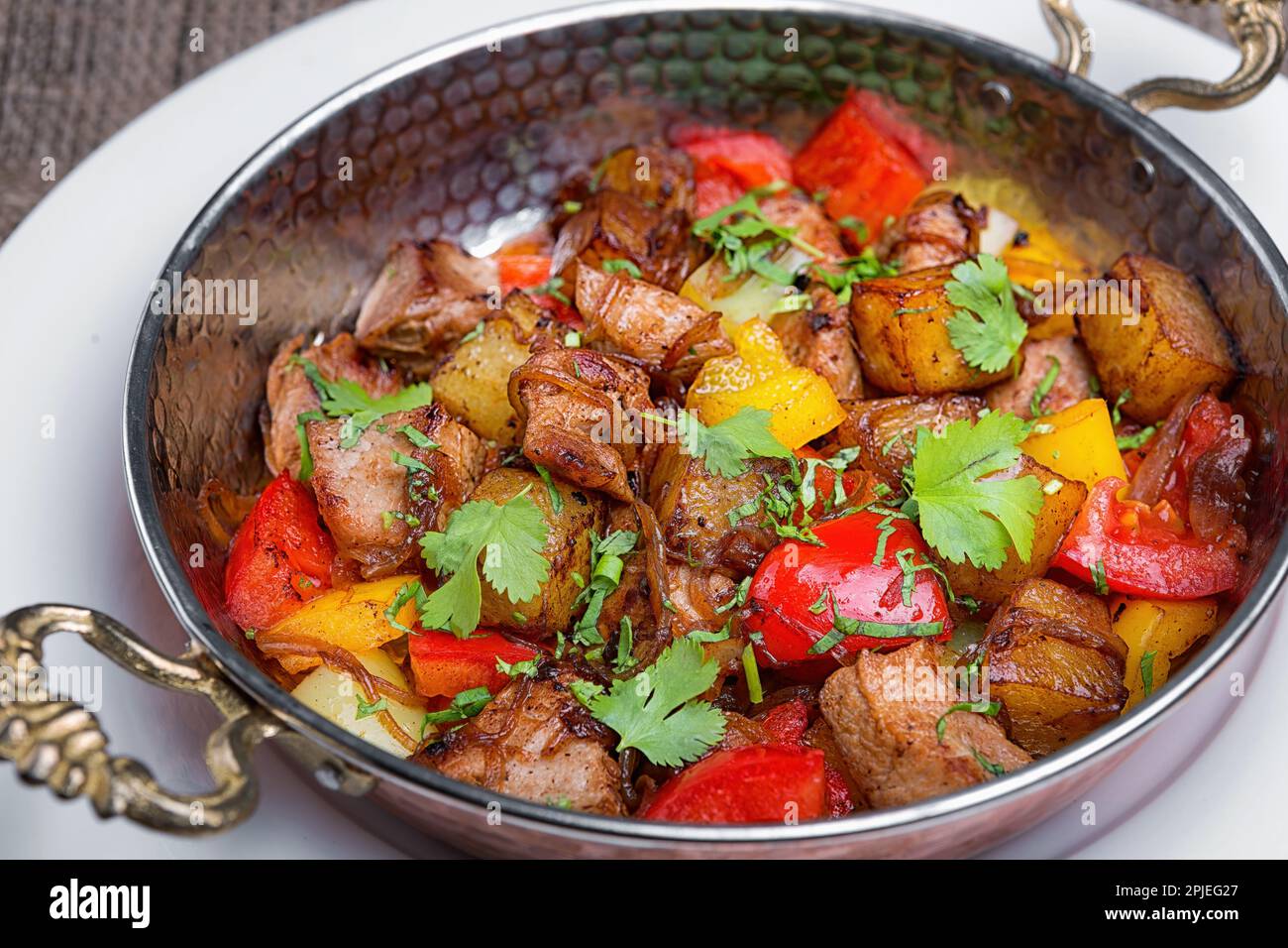 Vitello brasato saporito con patate di ispirazione orientale, verdure e prezzemolo Foto Stock