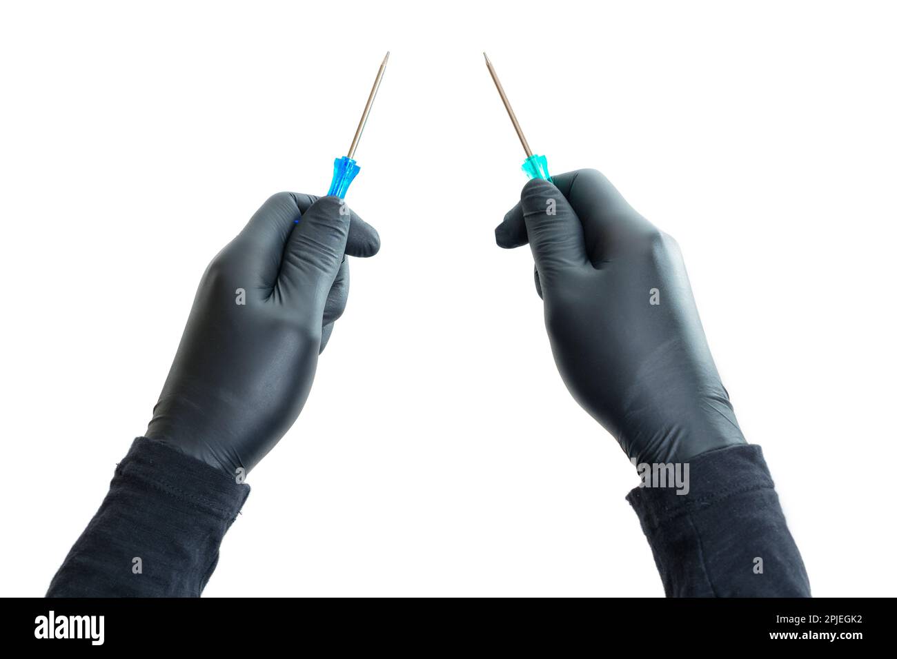 Le mani che indossano guanti in nitrile nero tengono isolati i cacciaviti su uno sfondo bianco. Concetto creativo professionale di handyman al lavoro. Foto Stock