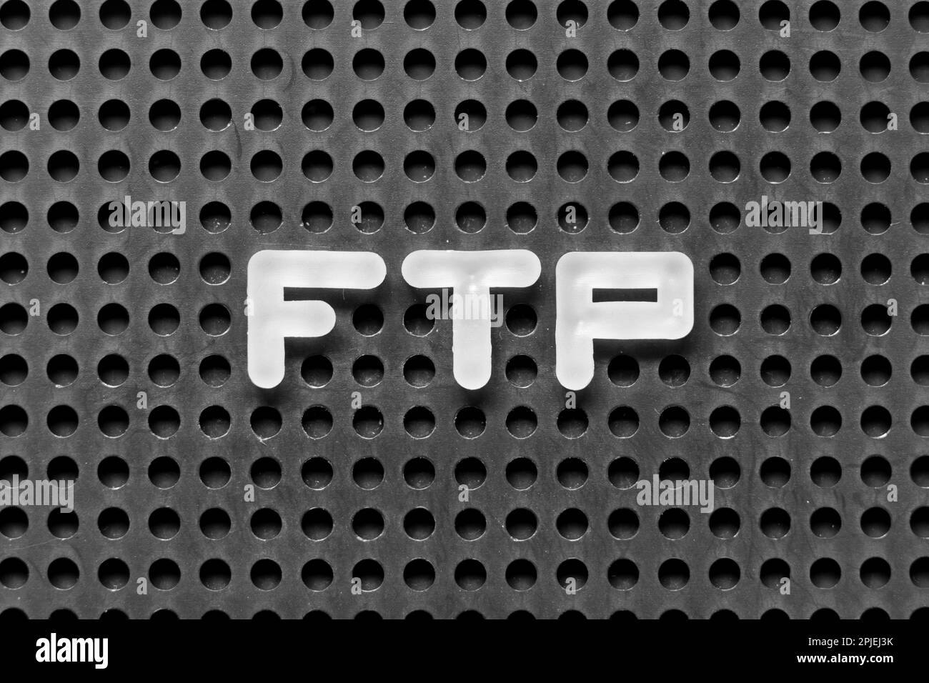 Lettera alfabetica bianca in parola FTP (abbreviazione di file Transfer Protocol) su sfondo nero di pegboard Foto Stock