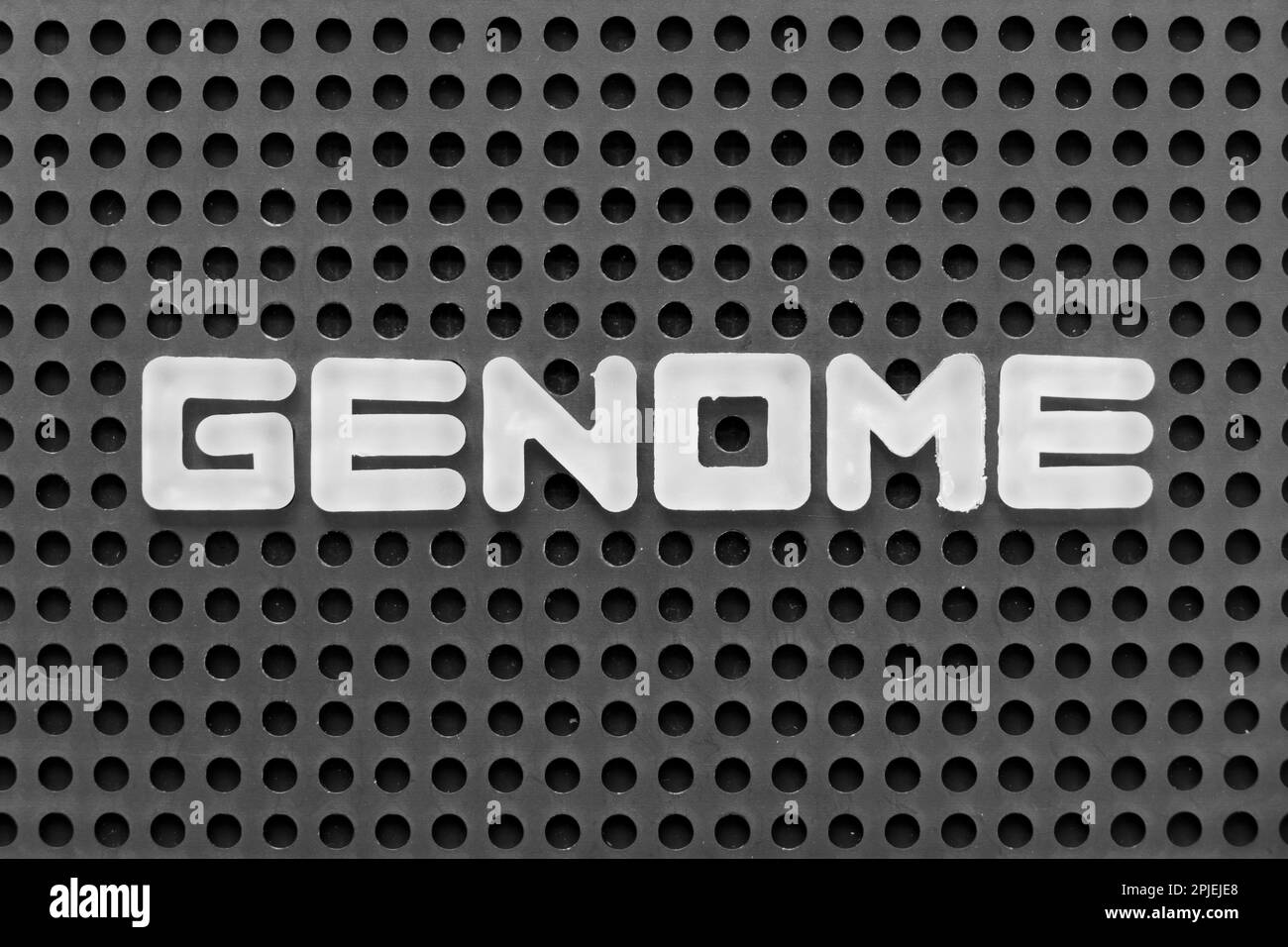 Lettera dell'alfabeto bianco in genoma di parola su fondo nero del pegboard Foto Stock