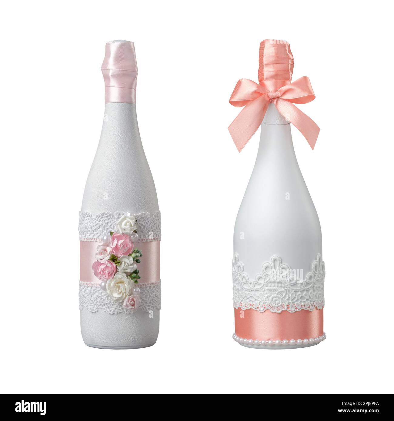 Due bottiglie di champagne da matrimonio decorate con fiori di rosa, pizzo e nastro. Isolato su bianco. Foto Stock