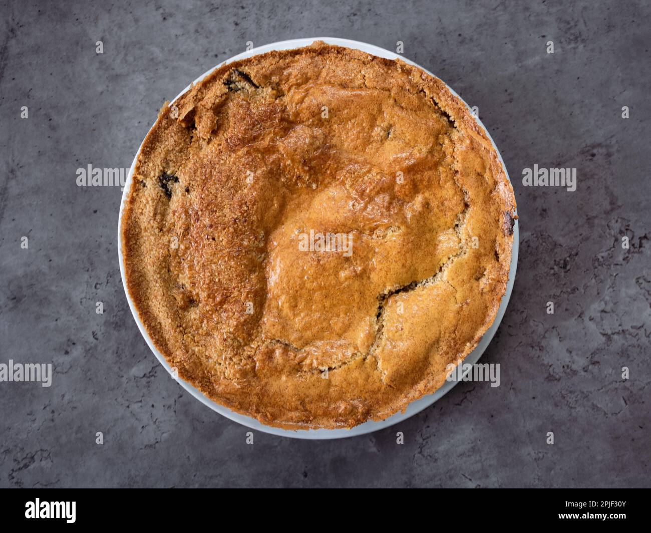 Una classica torta di mele crumble fatta in casa, conosciuta anche come torta di mele olandese, con una crosta croccante e centrata su uno sfondo scuro da tavolo. Vista dall'alto verso il basso Foto Stock