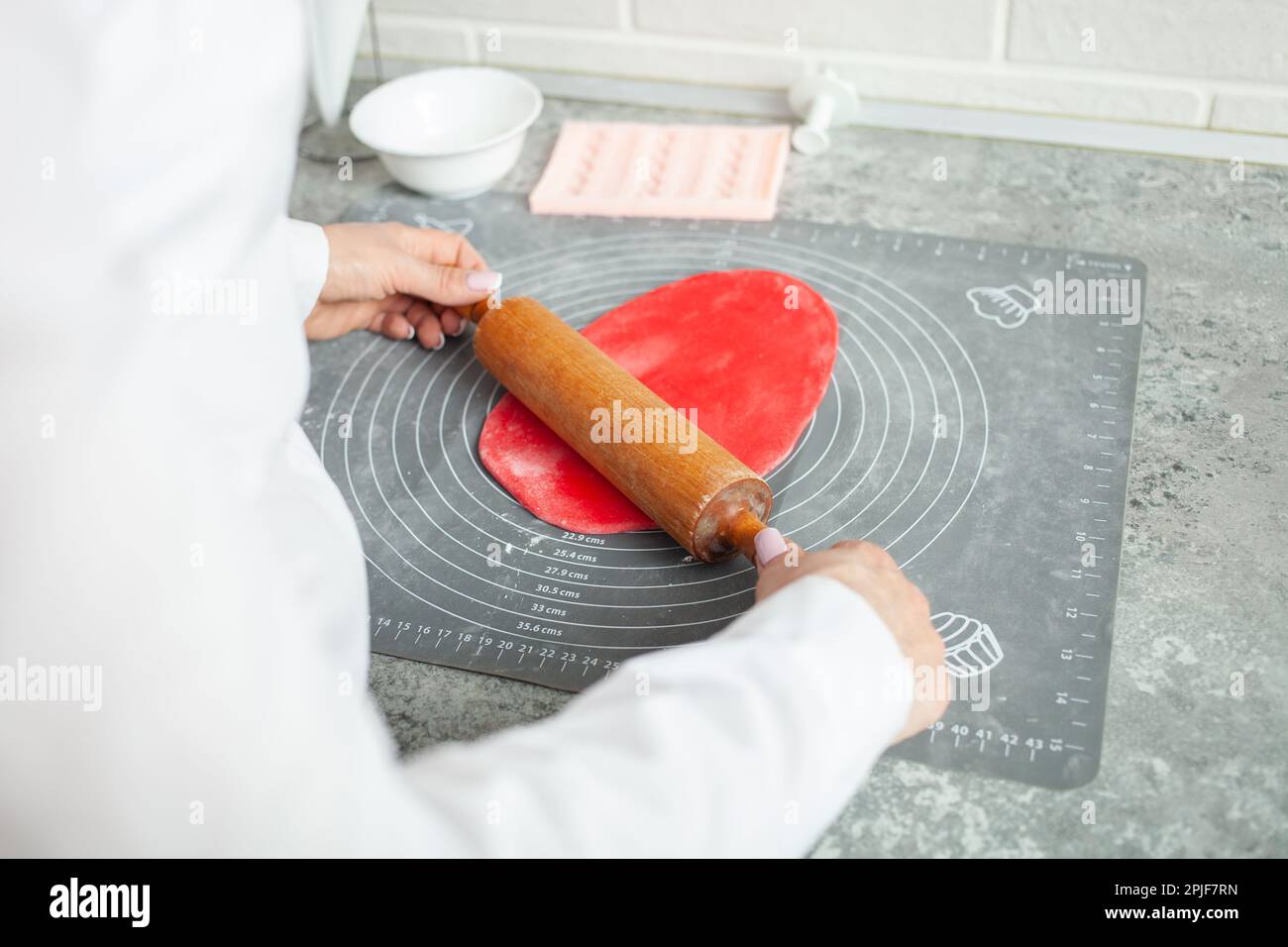 Il pasticciere fa il mastice per decorare la torta. Pasta elastica, deliziosi dolci, cottura. Produzione domestica, hobby, imprenditorialità. Foto Stock