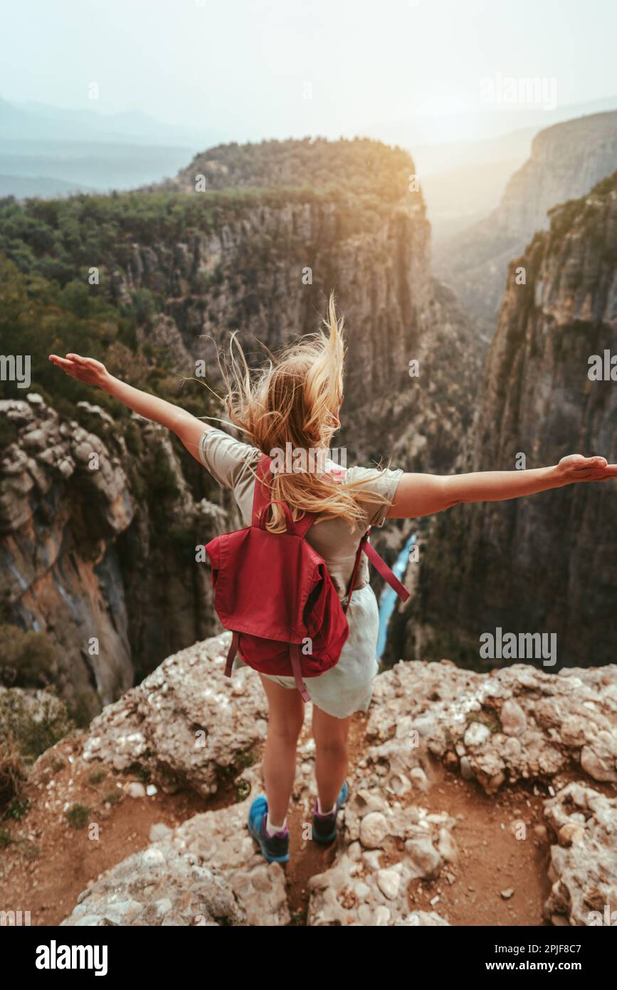 Donna all'aperto esplorando il canyon Tazi in Turchia viaggio lifestyle escursioni in montagna ragazza escursionista mani sollevate attive vacanze estive zaino in spalla Foto Stock