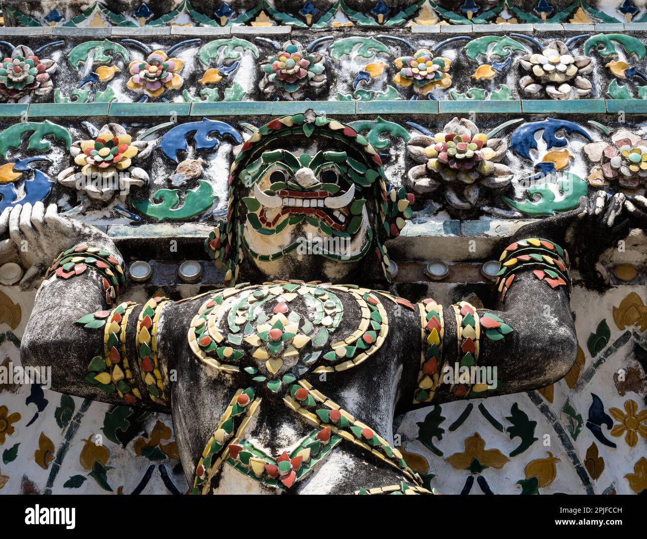 Ammira gli squisiti dettagli di una statua decorativa e colorata sulla facciata di Wat Arun, il Tempio dell'Alba, a Bangkok, Thailandia. Ammira il suo ingresso Foto Stock