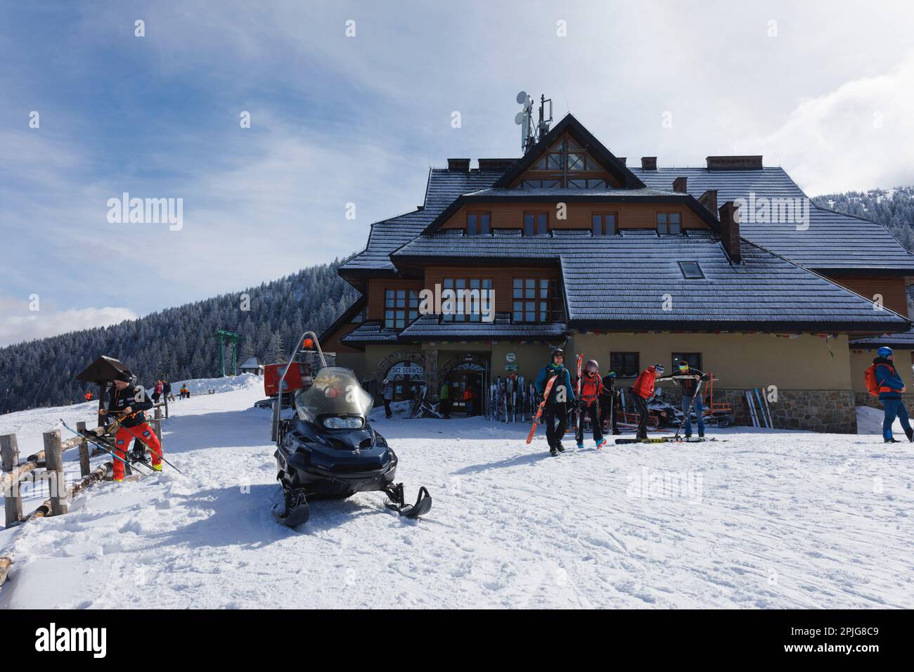 Hala Miziowa, Pilsko, montagne di Beskid, Polonia - 12 marzo 2023: Cabina di montagna, stazione sciistica, turisti e sciatori. Giorno di sole in inverno. Foto Stock