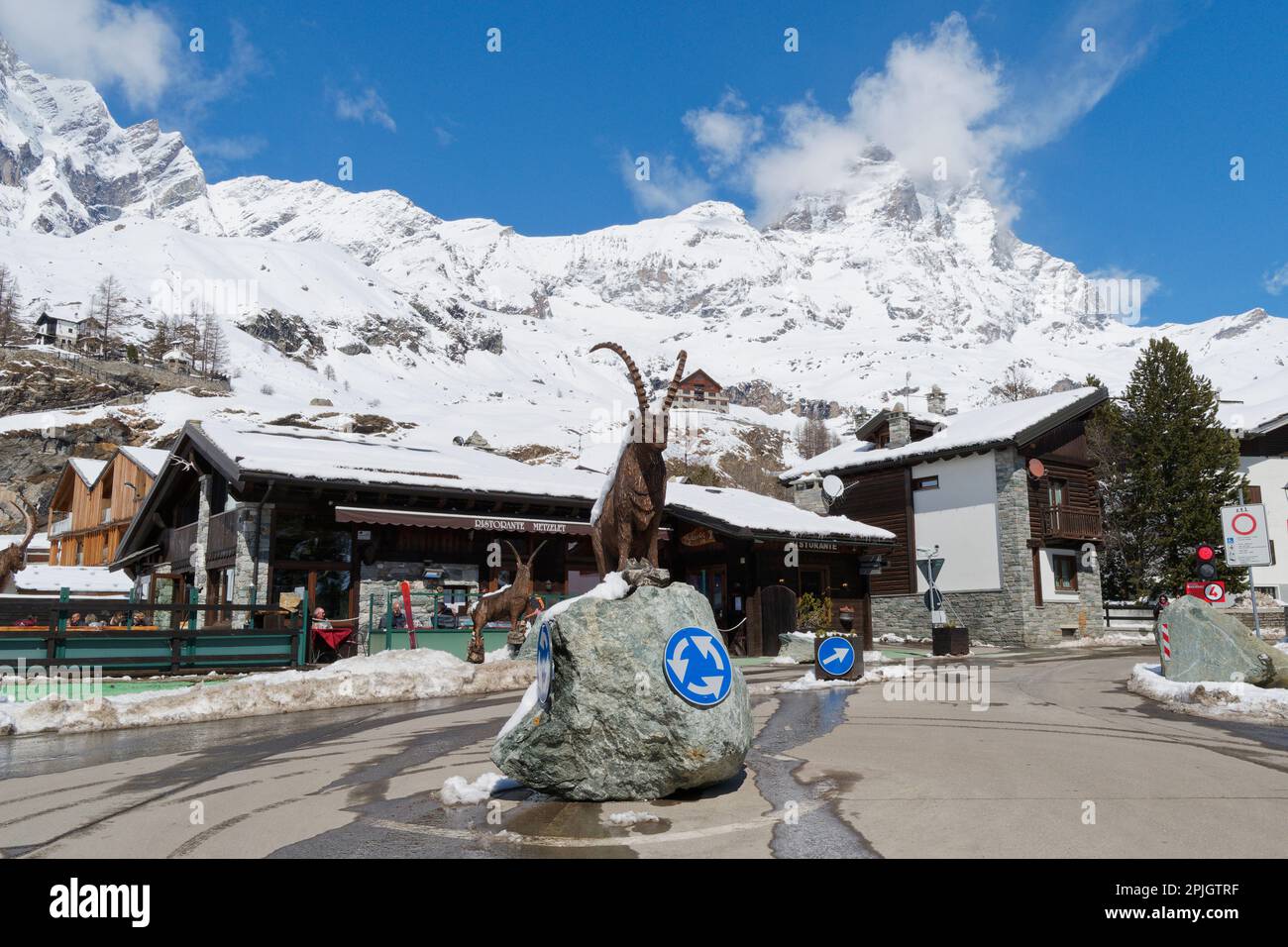 Rotonda con statua di renne con ristorante dietro a Breuil Cervinia, località sciistica in Valle d'Aosta NW Italia. CERVINO aka Mattern montagna dietro. Foto Stock