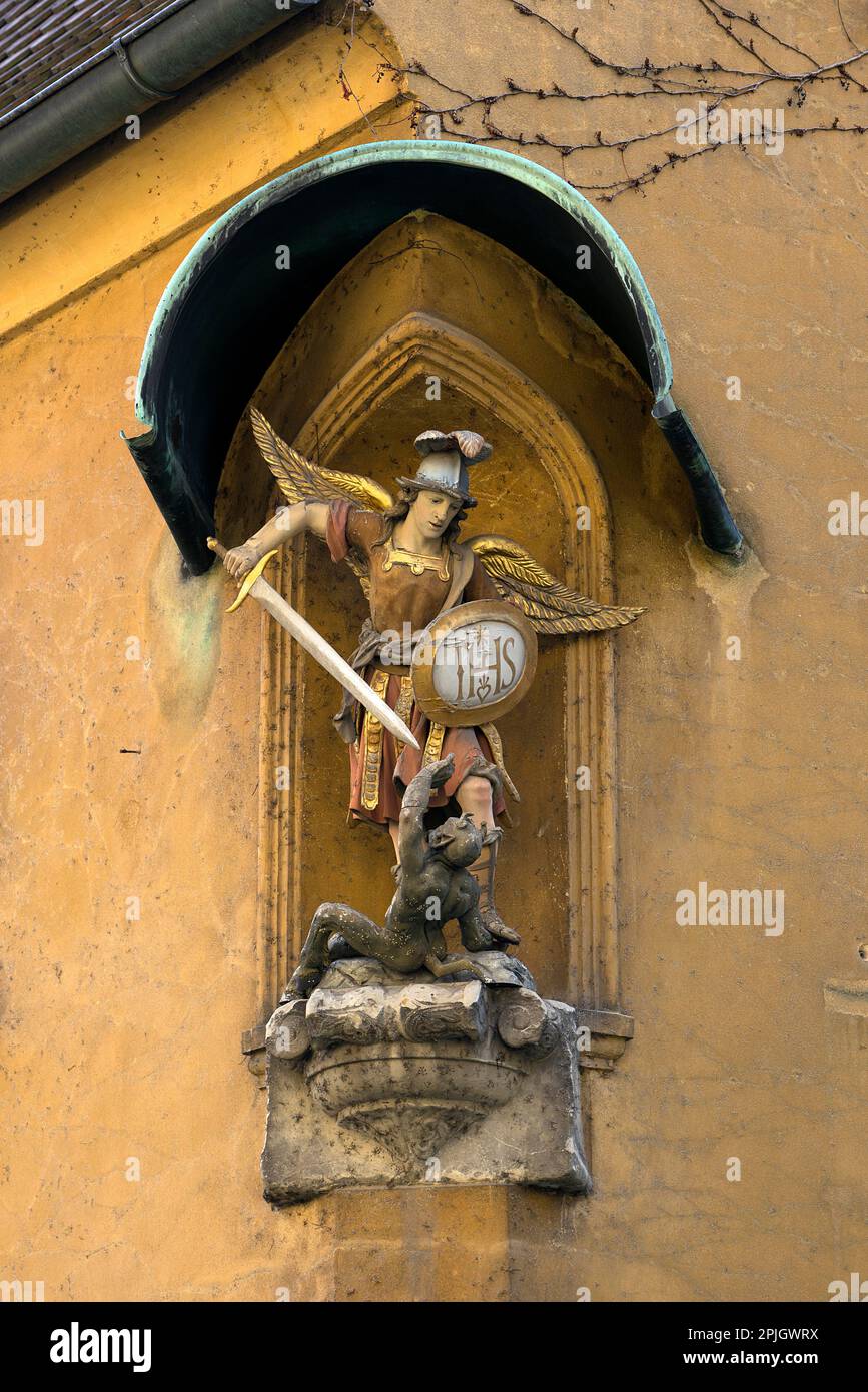 Scultura di San Michele Arcangelo combatte contro il diavolo, in un edificio residenziale nel Jakob Fugger Siedlung, Augusta, Baviera, Germania, Europa Foto Stock