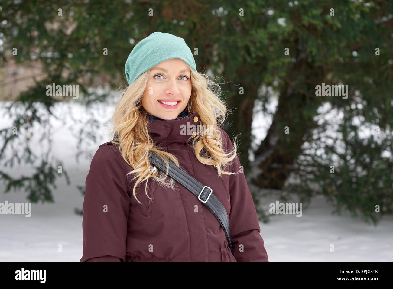 Donna bionda che indossa caldo inverno moda e cappello di lana godendo di inverno Foto Stock