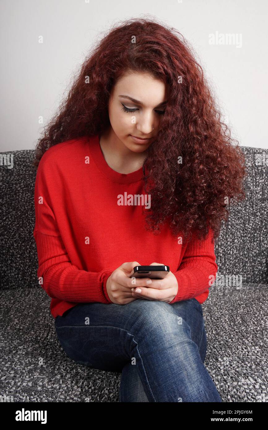 ragazza che controlla il suo smartphone per i messaggi di testo Foto Stock